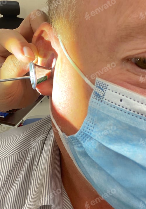 Preview: Middle aged baby boomer male wears a ppe face mask at the Eat Nose and Throat(ENT) doctor’s office
