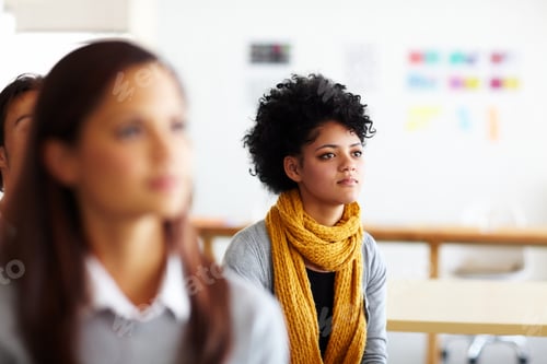 Preview: A beautiful young woman sitting and listening to a presentation