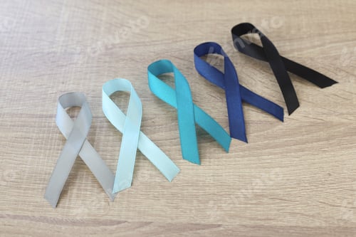 Preview: Multi-color ribbons on wooden background for cancer awareness
