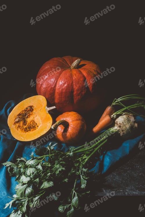 Preview: close-up view of ripe pumpkins, carrots and celery on cloth