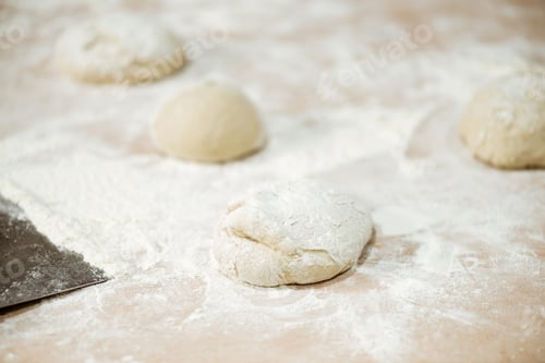 Preview: close-up shot of dough ball on table spilled with flour