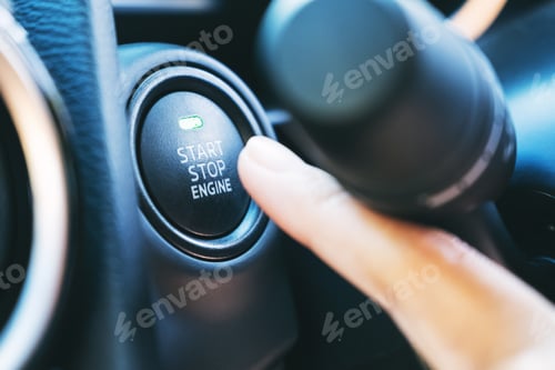 Preview: Closeup image of a finger pressing on a start stop engine button in a car