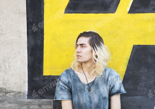 Preview: Attractive Armenian guy looking away on a yellow and black wall background