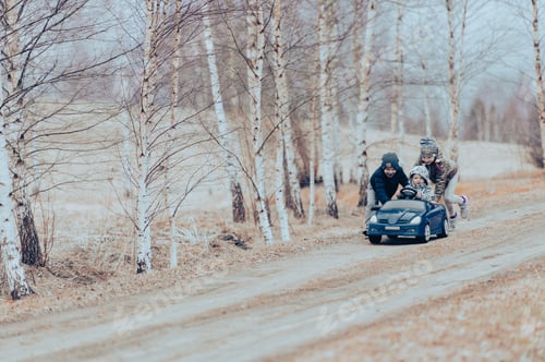 Preview: Three happy children playing with big old toy car in countryside, outdoors.