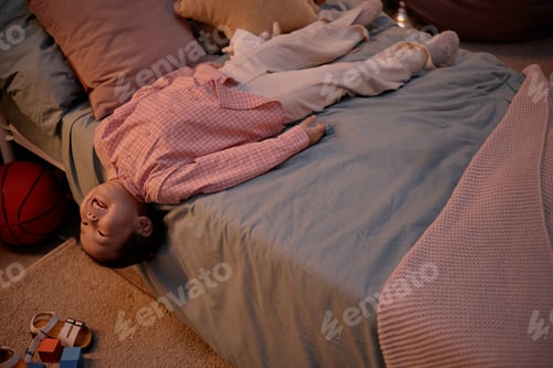 Preview: Asian Child Lying Upside down on Bed Relaxing during Evening at Home