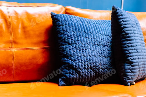 Preview: Close up detail of blue pillow on leather sofa