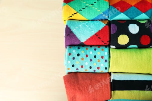Preview: Rolled colorful socks on light background, top view