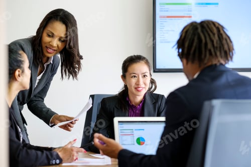 Preview: Businessman and businesswomen, in office meeting, using laptop, looking at data