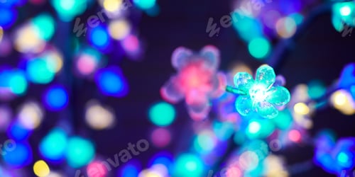 Preview: Multicolored lights bokeh from decorative luminous flowers garlands at holiday, multicolored lights