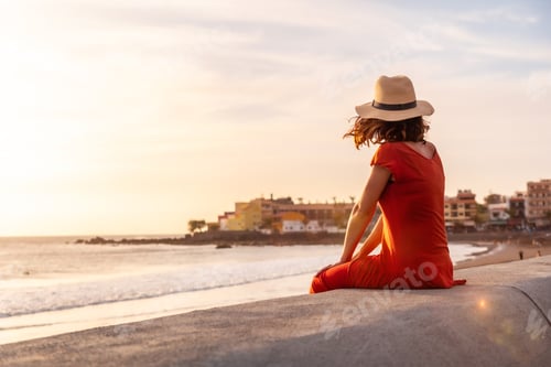 Preview: Tourist woman at sunset enjoying vacations on the beach of Valle Gran Rey village in La Gomera