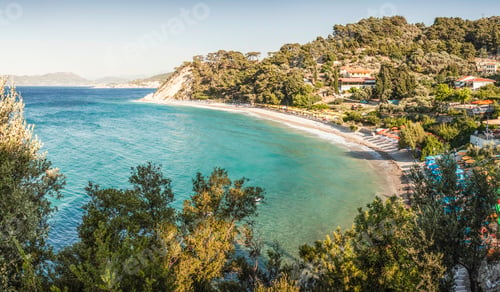 Preview: Serene coastal panorama featuring a beautiful beach and lush greenery