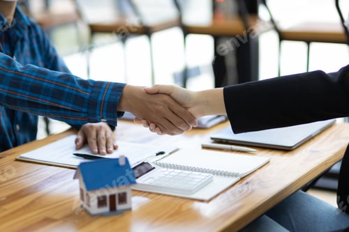 Preview: Businessman and real estate agent shaking hands after negotiating home purchase agreement.
