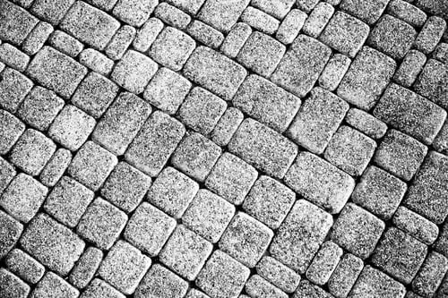 Preview: Black and white tiles lying diagonally. Stone wall. A great background for your design.