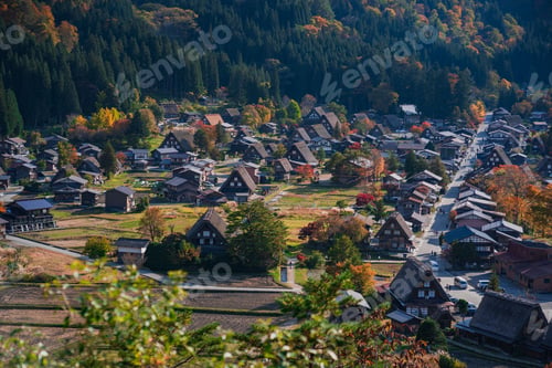 Preview: Traditional houses in Shirakawa Go in Japan surrounded by autumn forest trees on a sunny day