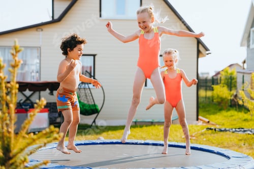 Preview: Joyful kids jumping on a garden trampoline, with a house in the background, sunny day