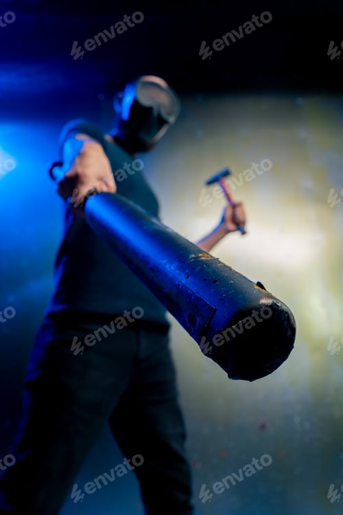 Preview: close-up man robber in mask holding baseball bat and hammer in hand threats attack robbery crimes
