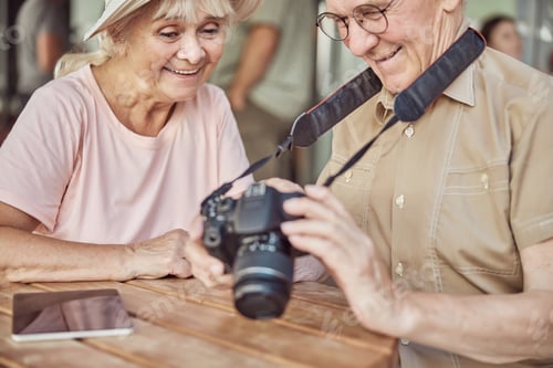 Preview: Cheerful modern senior couple sitting in a cafe