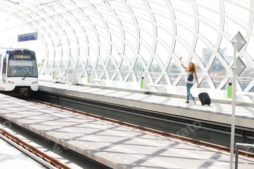 Preview: woman with bags running on platform in station to catch train