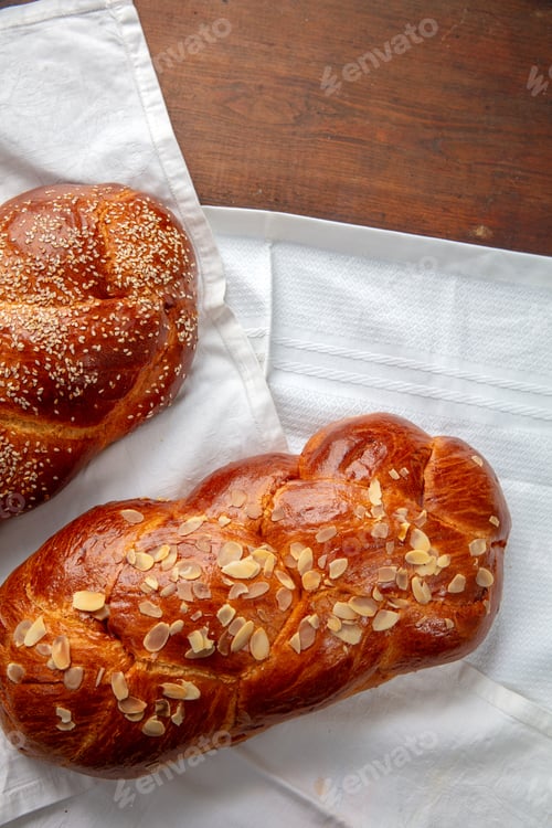 Preview: Easter sweet bread, two tsoureki braids on a white cloth on the table