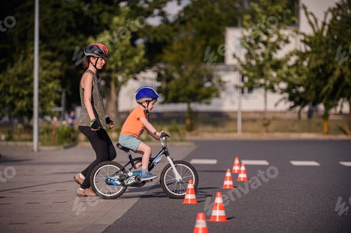 Preview: Child Practicing Bike Riding with Adult Guidance Outdoors