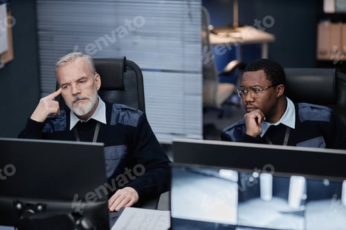 Preview: Middle Aged Caucasian Man and Black Man Monitoring Security Footage Together
