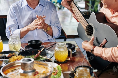 Preview: Man playing guitar at dinner