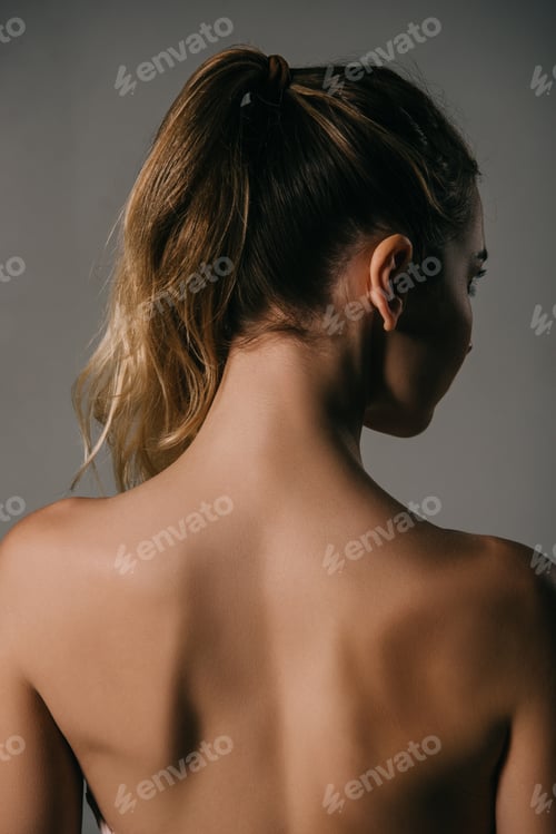 Preview: back view of girl with ponytail on grey background