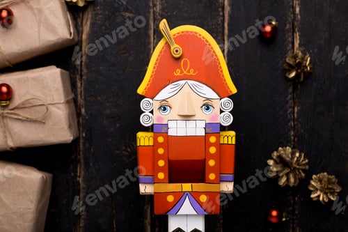 Preview: Nutcracker toy with gifts with a New Year's decor on a wooden background