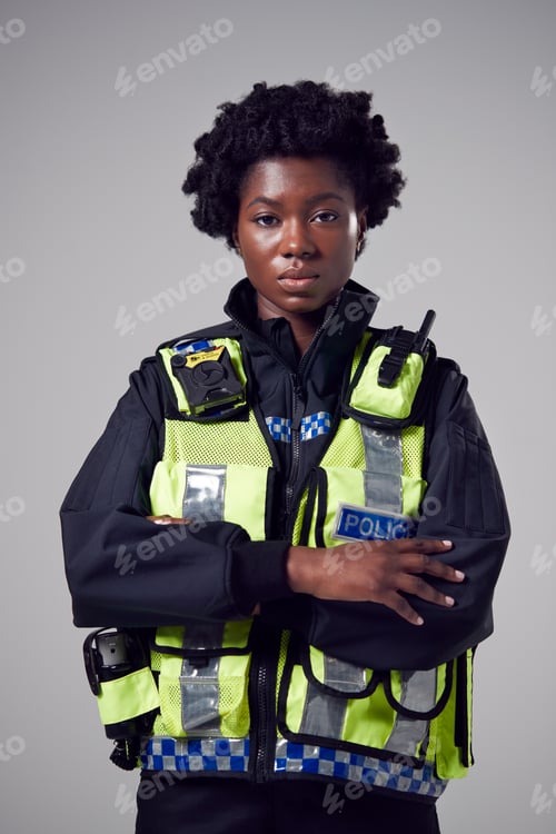 Preview: Studio Portrait Of Serious Young Female Police Officer Against Plain Background