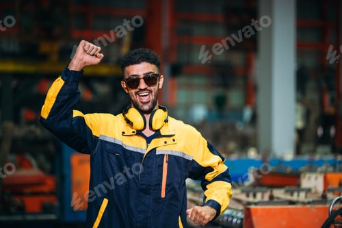 Preview: Portrait of happy industrial worker looking camera at factory machines.