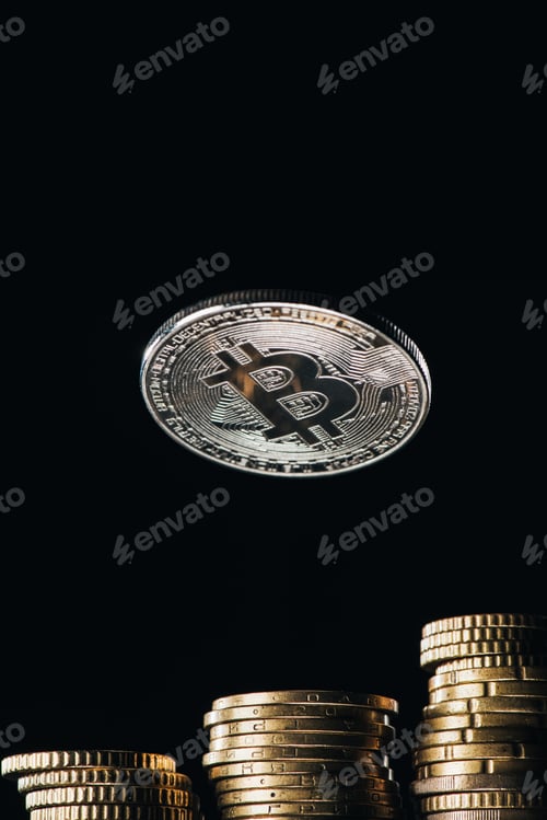 Preview: Close up view of silver bitcoin and stacks on cents isolated on black