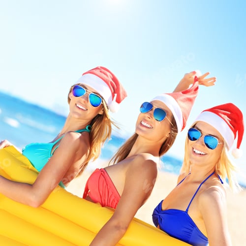 Preview: Group of girls in Santa's hats having fun on the beach
