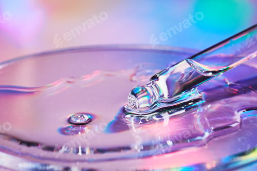 Preview: Pipette with sample of cosmetic product in petri dish on iridescent holographic background