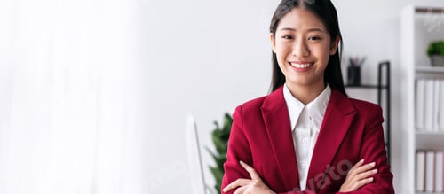 Preview: Confident businesswoman in suit smiling and standing with arms c