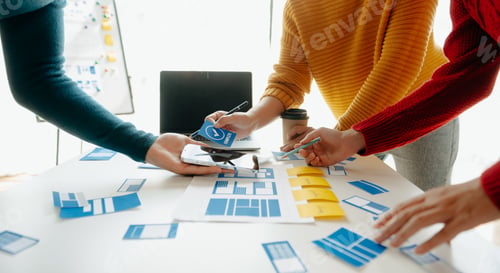 Preview: Close up view of UI developer team brainstorming on their project with laptop,