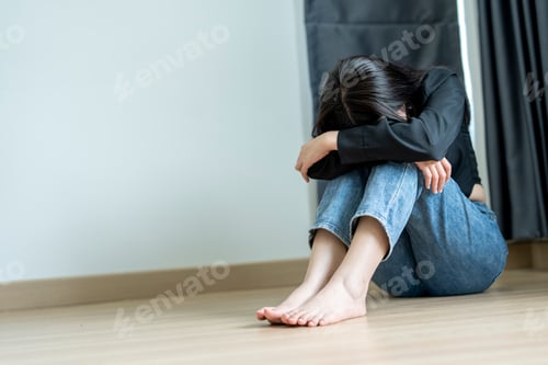 Preview: Young woman feeling sad sitting alone on the floor