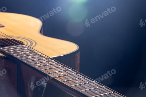 Preview: Part of acoustic guitar on black background copy space.