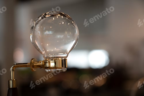 Preview: Elegant glass siphon coffee makers gleam with golden accents