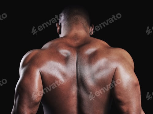 Preview: Most ardently. Rearview studio shot of a fit young man flexing against a black background.