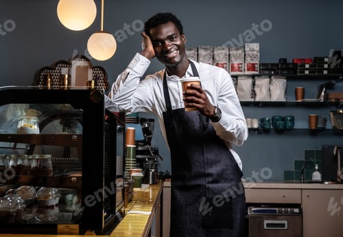Preview: Barista holding a cup with coffee in a coffee shop