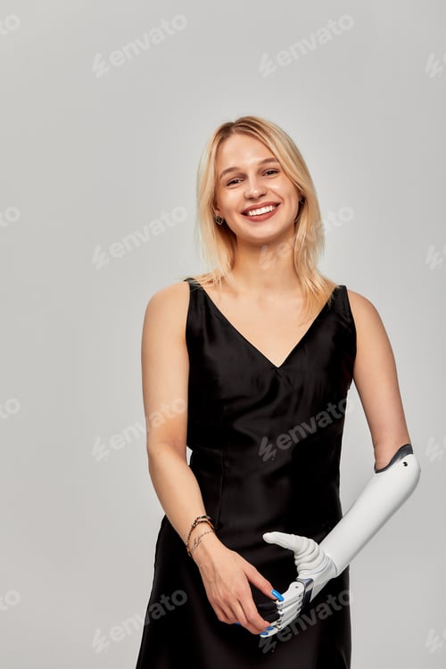 Preview: Studio portrait of beautiful young blonde girl with disability wearing sensory bionic prosthetic arm