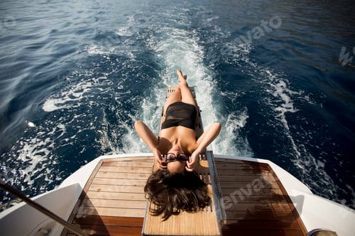 Preview: Woman Relaxes on Back of Boat in Ocean