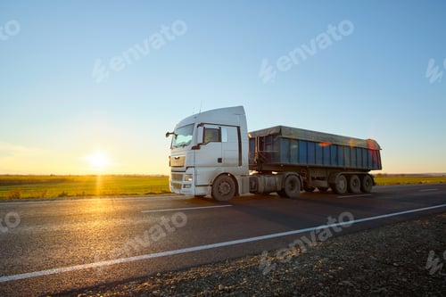 Preview: Semi-truck with tipping cargo trailer transporting sand from quarry driving on highway
