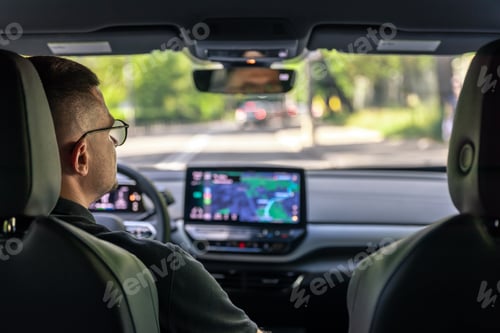 Preview: Man touching screen of a GPS navigation system in his car.
