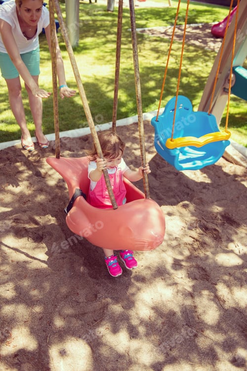 Preview: mother and daughter swinging in the park