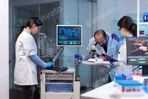Preview: Group of scientists doing research and experiments at medical lab against disease with special