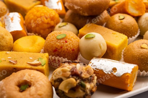 Preview: Group of Indian assorted sweets or mithai with diya