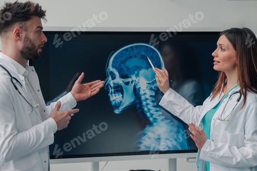 Preview: Doctors discussing x ray image of skull and brain on monitor