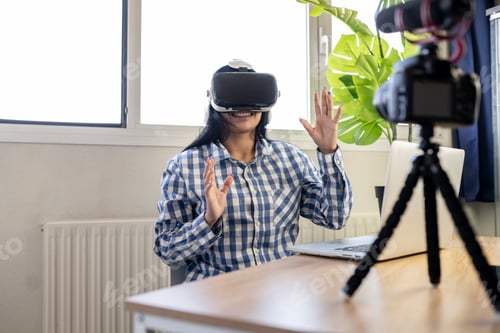 Preview: handsome woman in her office doing a video conference with virtual reality glasses