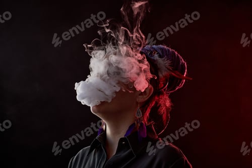 Preview: Thick cloud of white vapor hiding face of young smoking woman
